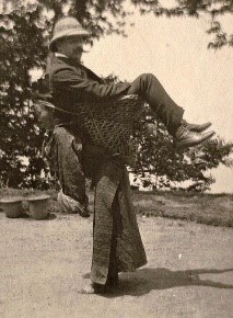 The following photograph of a British merchant being carried by a lady on her back in Bengal has been taken in 1903.